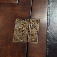Decorative brass hinge detail on walnut secretary bookcase.
