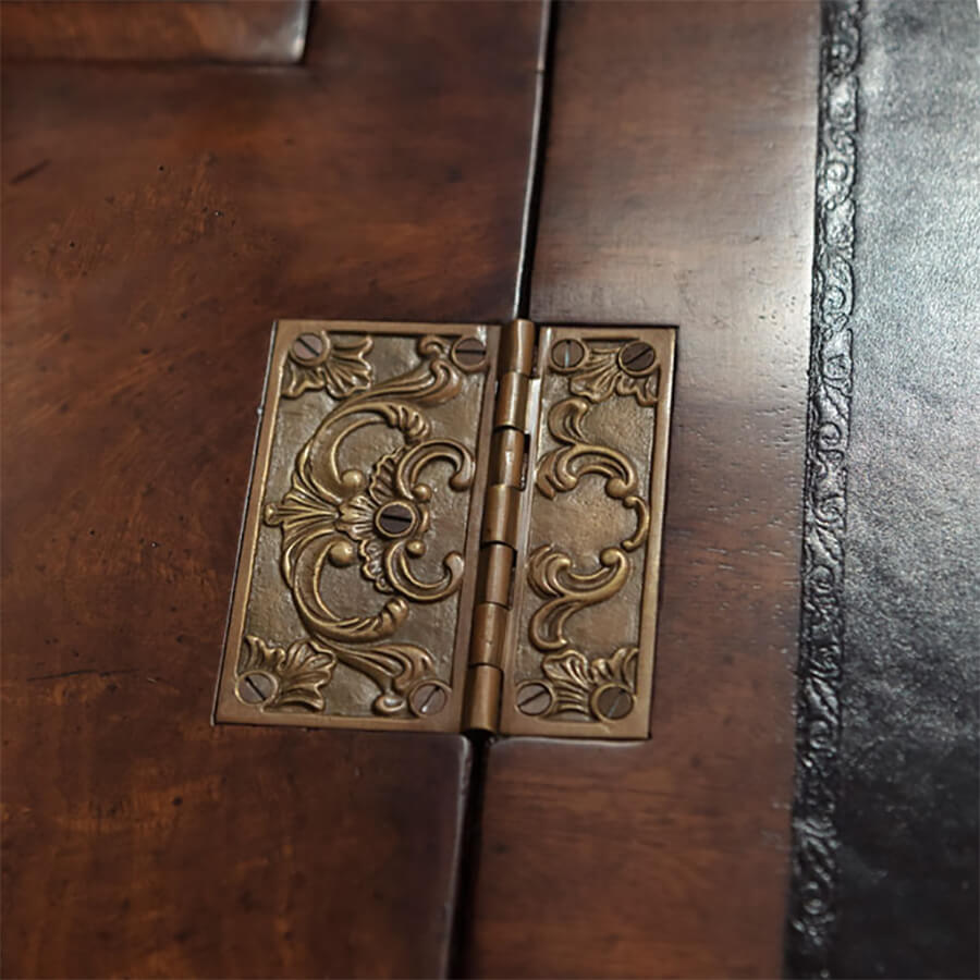 Decorative brass hinge detail on walnut secretary bookcase.